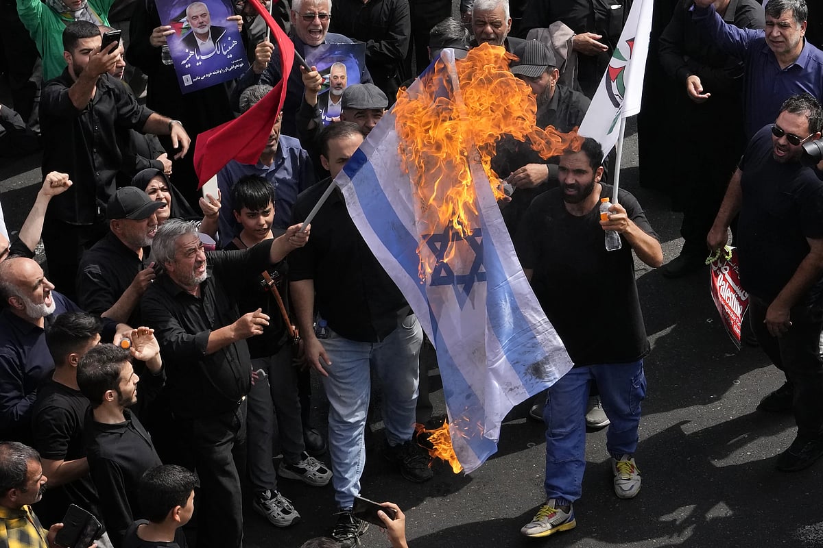 Iranians burn Israeli flag during the funeral ceremony of Hamas leader Ismail Haniyeh | - AP